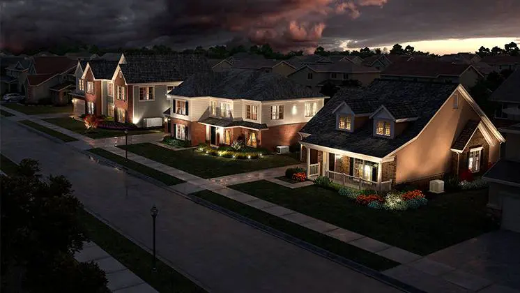 A row of suburban homes on a street in the evening with dark clouds in the background.
