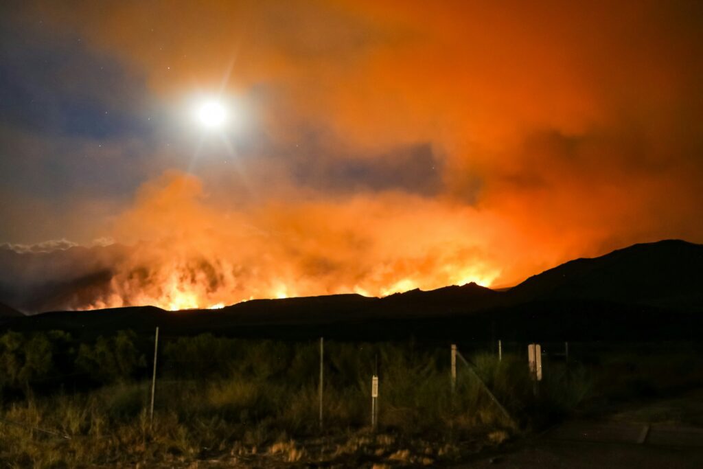 Distant view of wildfire spreading across the Sierra Nevada mountains in California.